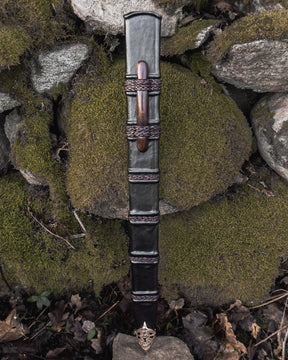 Svärdskida, Braid of glory - läderslida med flätad metalldekor och trähandtag, vertikalt perspektiv på stenar