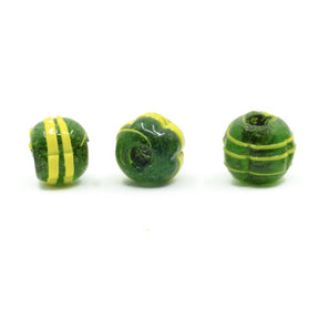 Mörkgrön melonformad glaspärla med gul dekor. Klassisk vikingatida pärlform med gul spiral- och linjdekor på mörkgrön grund. Tre rotationsvinklar på vit bakgrund.